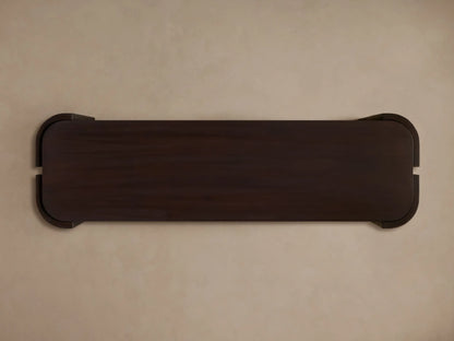 Dark brown Chiseled Console Table, front view. Hand-carved legs with textured finish wrap around two dark wood shelves.