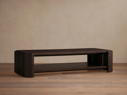 Dark mahogany Chiseled Coffee Table, two-tiered, with artisan hand-carved legs, on a wooden floor.