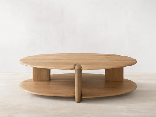 Nolito Coffee Table: Rounded, two-tier wood table with beveled edges and curved supports, showcasing two harmonious tones.