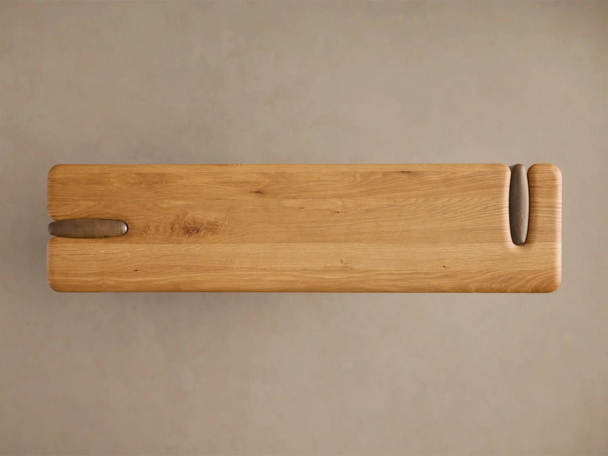 Top-down view of the natural wood Nolito Console Table, showing its rounded silhouette, beveled edges, and dark wood curved details.