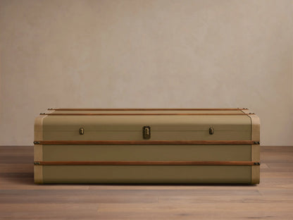 Front view of the olive Oberlin Storage Coffee Table, a trunk-style table with beige leather trim, a brass-tone lock, and wooden bands.