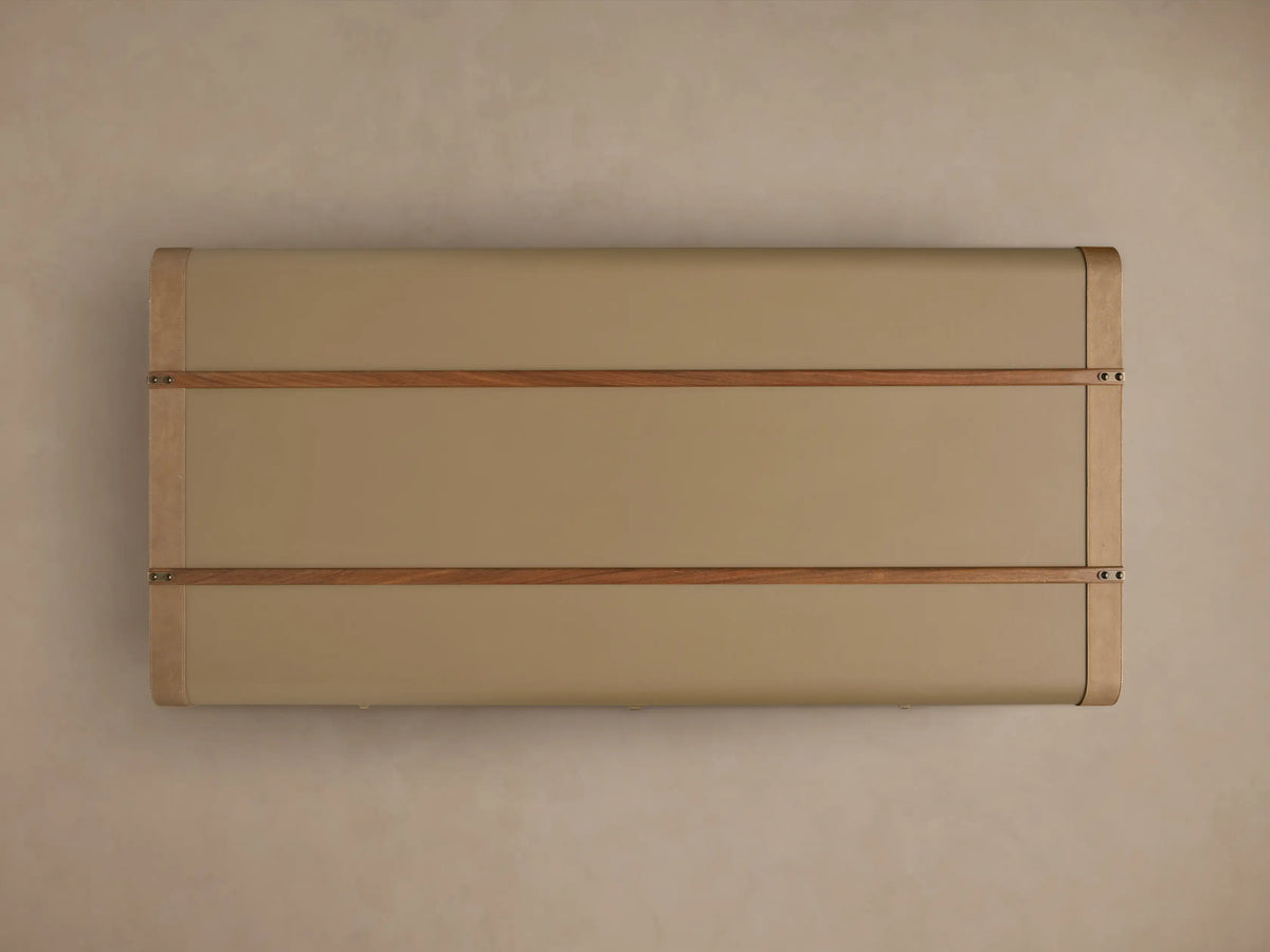 Front view of the olive Oberlin Storage Coffee Table, a trunk-style table with beige leather trim, a brass-tone lock, and wooden bands.