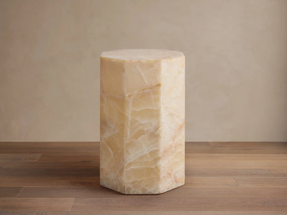 Odelia Onyx Stool: Octagonal column of honed ivory and beige onyx with natural veining, on a wood floor.