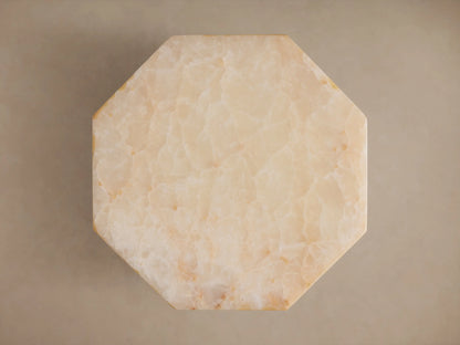 Close-up of Odelia Onyx Stool, an octagonal ivory and beige honed solid onyx stool with natural color variations.