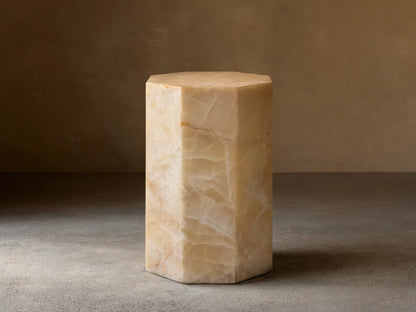 Odelia Onyx Stool: Octagonal column of honed ivory and beige onyx with natural veining, on a wood floor.