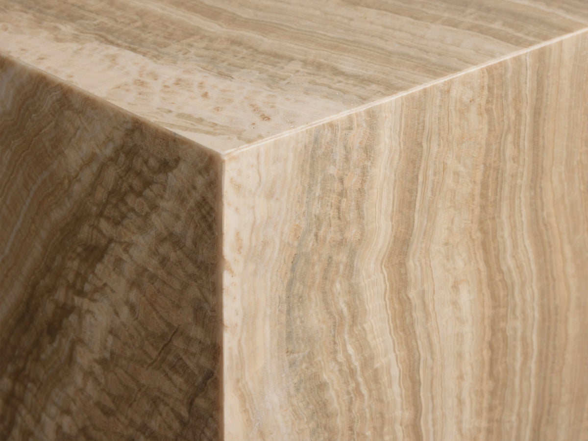 Grey Onyx Stool, a rectangular block of natural onyx with swirling beige, brown, and cream veining. On wood floor.