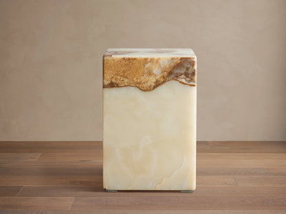 Rust Onyx Stool: rectangular block with a prominent horizontal band of rustic brown/gold/red onyx atop smooth ivory/green onyx, on a wood floor.