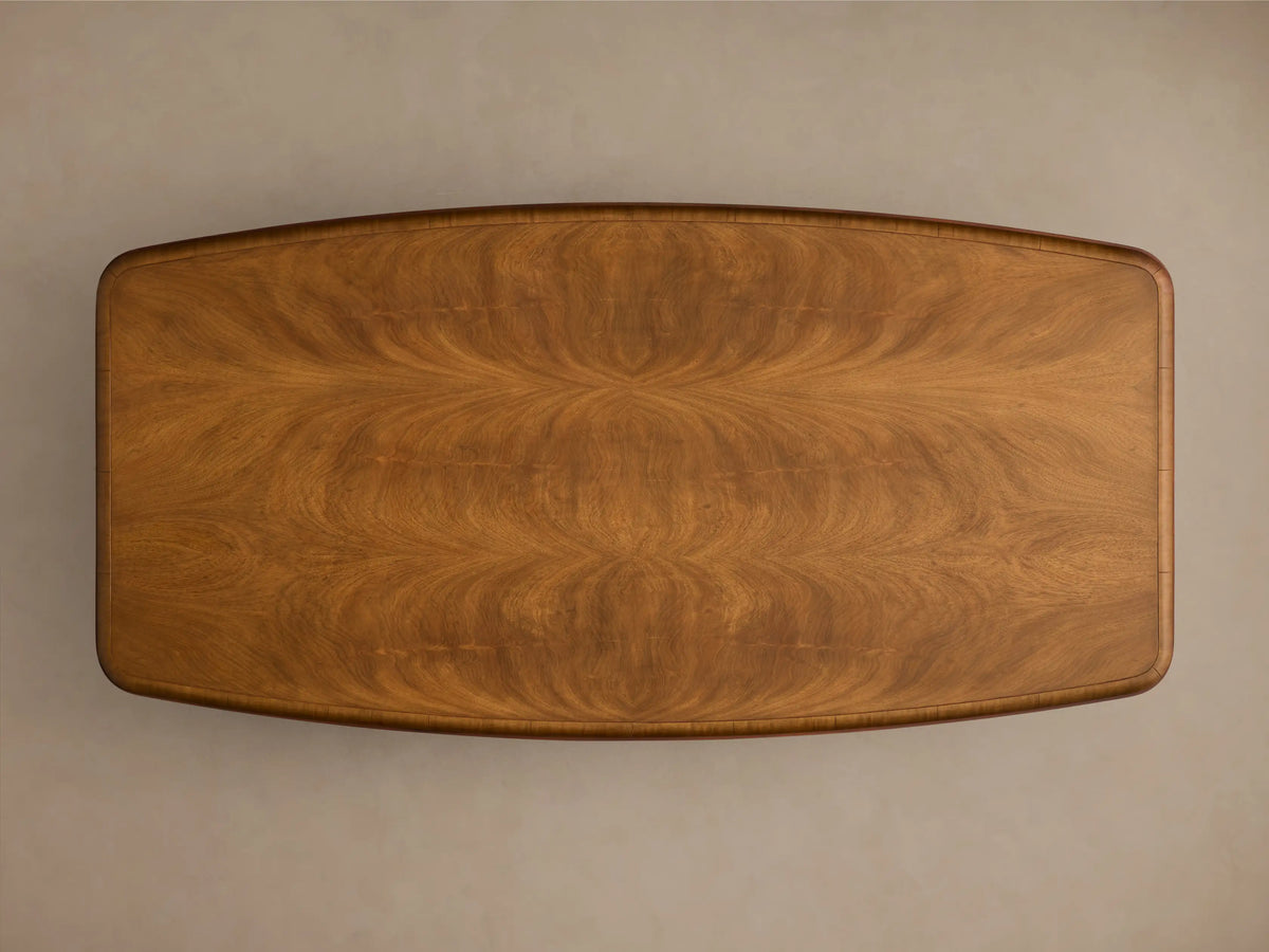 Angled view of the Palma Coffee Table, showing medium brown cerajeira wood veneer with wavy grain and dark brown trim.