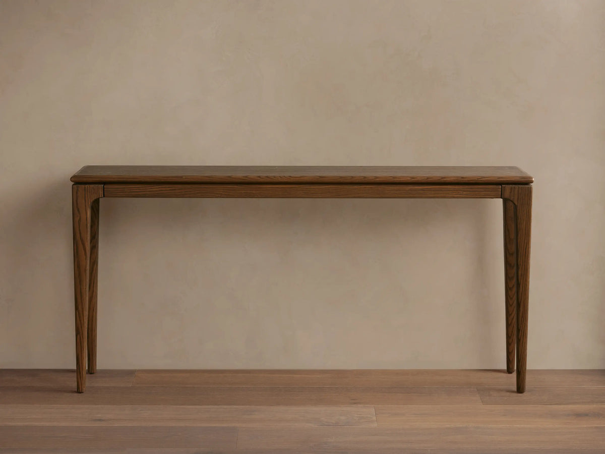 Dark oak Park Console Table with sleek design, straight legs, styled with a textured vase & white flowers on a light wood floor.
