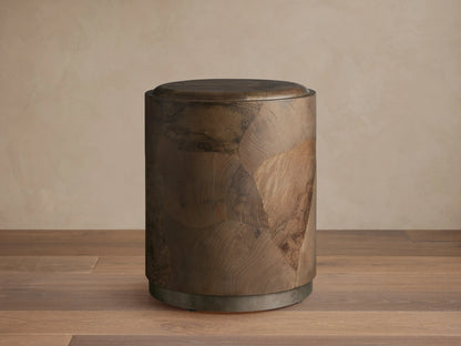 Polanco Round Plinth End Table, dark natural wood with oyster-cut fragments, cylindrical shape, on a weathered metal base.