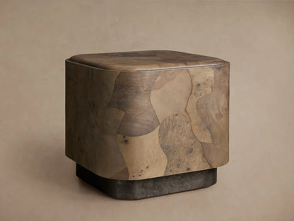 Polanco Plinth End Table, a block-shaped table with rounded edges, crafted from varied brown oyster-cut wood burl fragments. Dark plinth base.