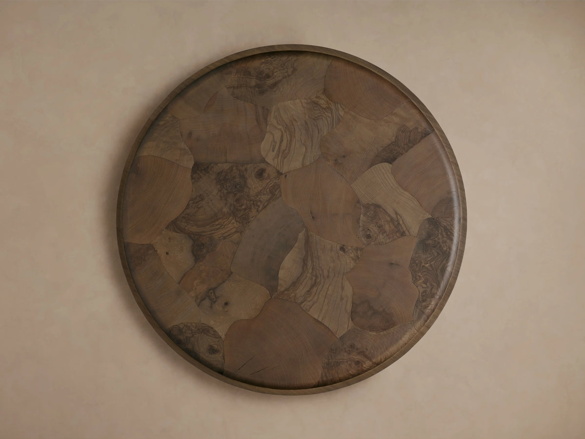 Circular Polanco Round Plinth Coffee Table with a mosaic of oyster-cut wood fragments in varied natural tones, featuring curved edges.
