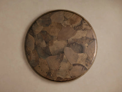 Polanco Round Plinth Coffee Table with oyster-cut ash fragments creating a mosaic pattern. Tabletop has a smooth finish with varied wood tones.