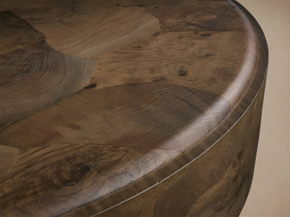 Polanco Round Plinth Coffee Table with detailed wood grain pattern, curved edges, and a glossy finish showing natural imperfections.