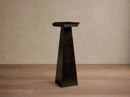 Dark Redge Hexagonal Martini Table with tapered base, dark madrona burl wood and swirling grain, on a wooden floor.