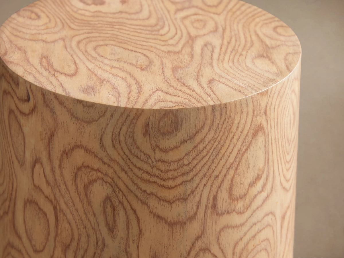 Redge Martini Table, a light-colored, tapered wood cylinder with swirling madrona burl grain, standing on a wooden floor.