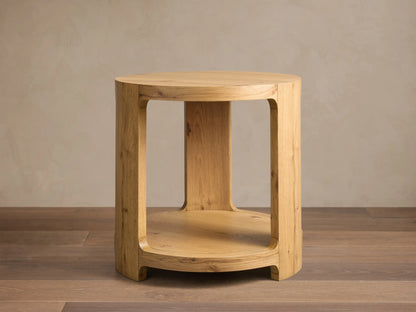 Front view of the natural white oak Redding End Table, featuring a round top and lower shelf supported by curved, thick legs.