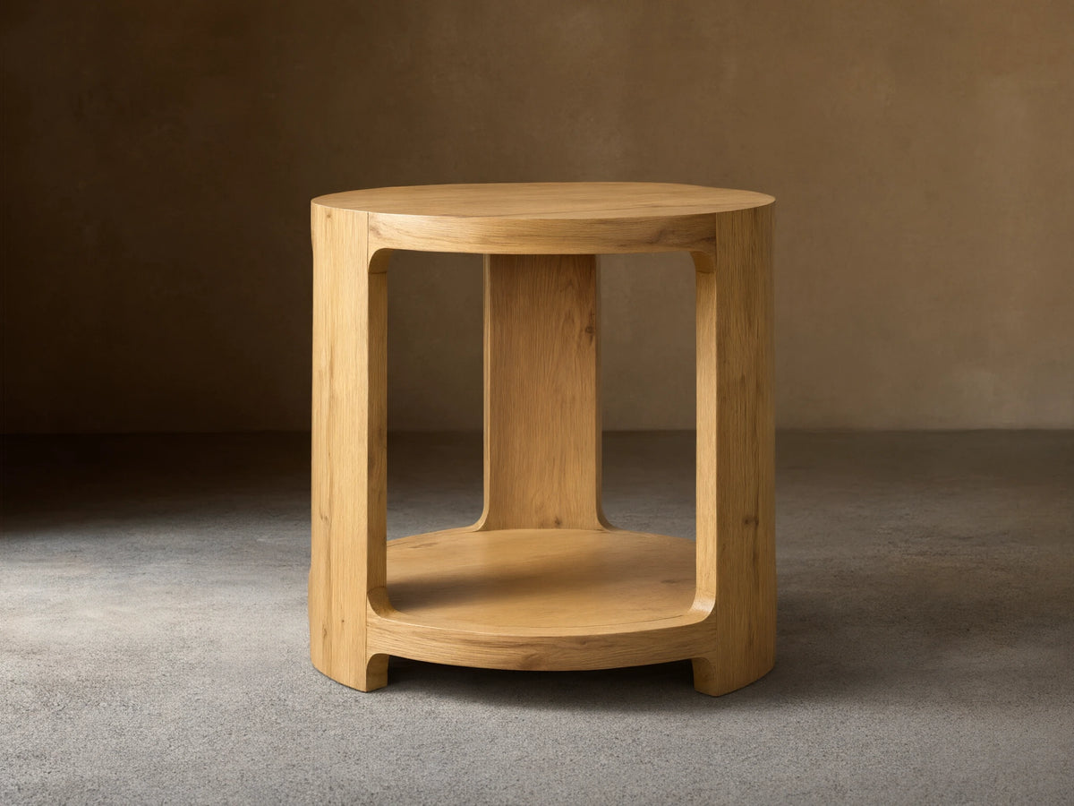 Front view of the natural white oak Redding End Table, featuring a round top and lower shelf supported by curved, thick legs.