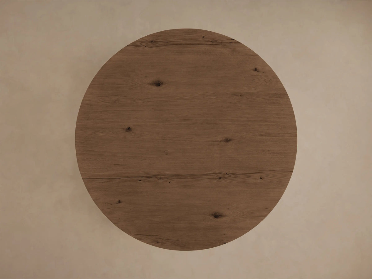 Top-down view of the Redding Round Coffee Table, showing its round medium brown wooden surface with visible grain and knots.