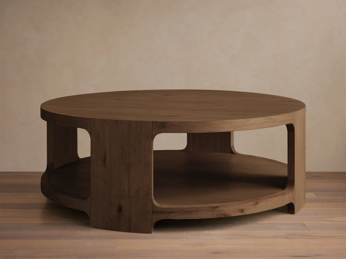 Front view of a dark brown Redding Round Coffee Table made of stained knotty white oak with a lower shelf.