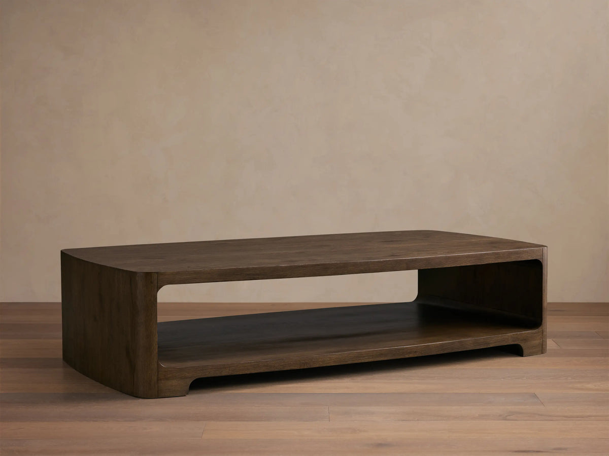 Close-up of the dark brown Redding Coffee Table, showing the wood grain, rounded top edge, and open lower shelf.