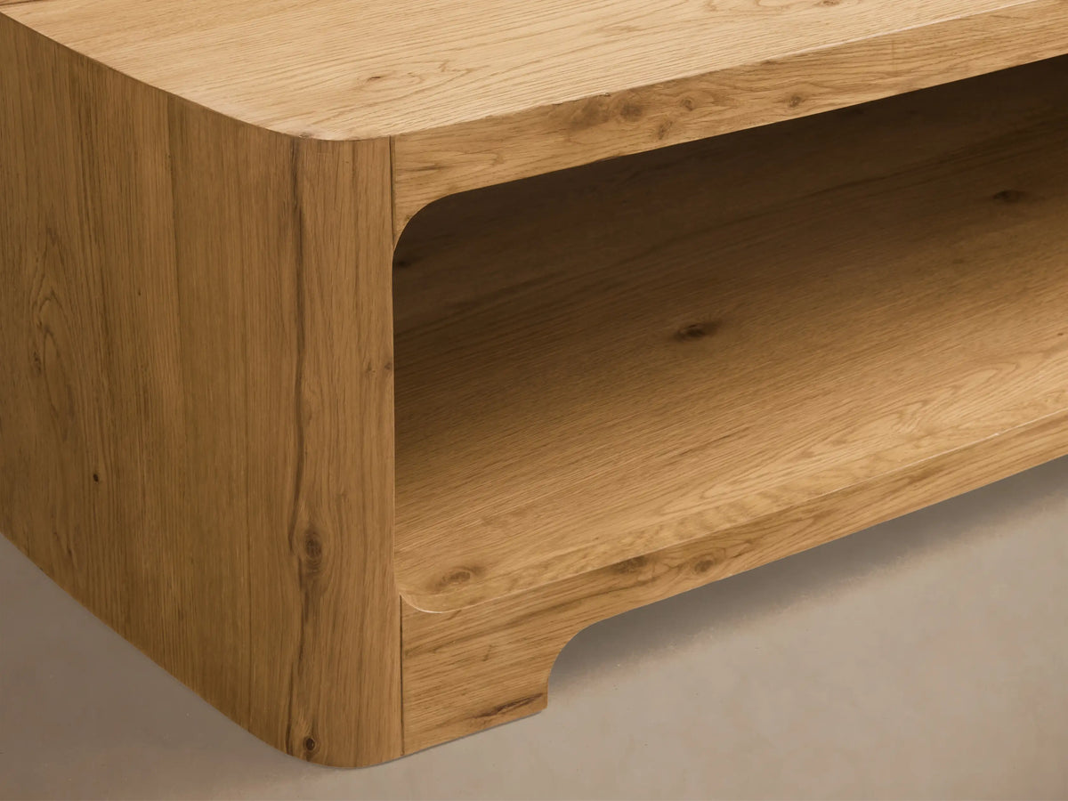 Front view of a light wood Redding Coffee Table, featuring rounded edges and a built-in lower shelf.