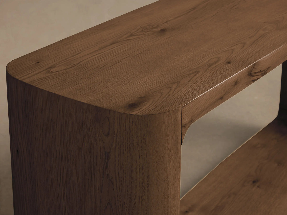 Close-up of the dark brown oak Redding Console Table, featuring rounded corners, prominent wood grain, and a visible lower shelf.