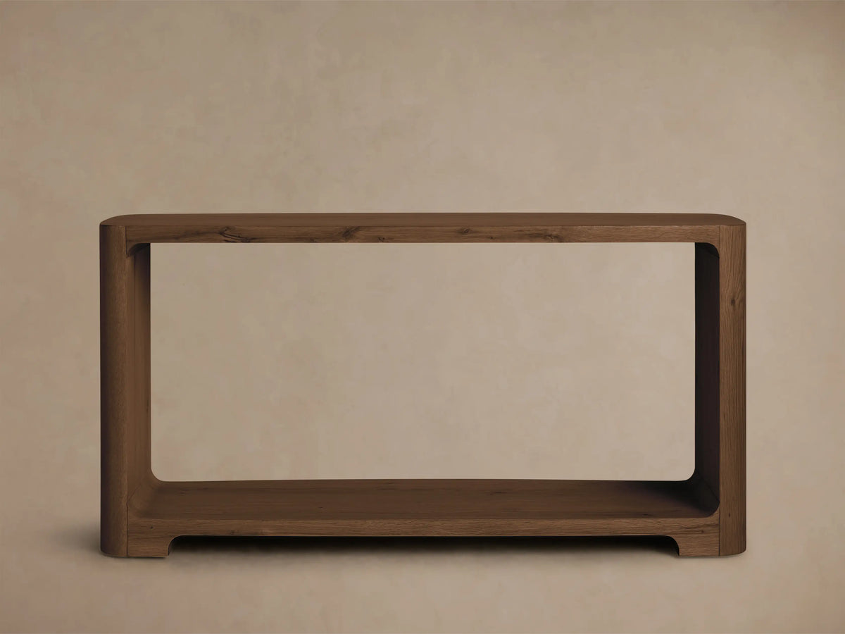 Front view of the dark brown Redding Console Table with a lower shelf and rounded edges, styled with vases and books.