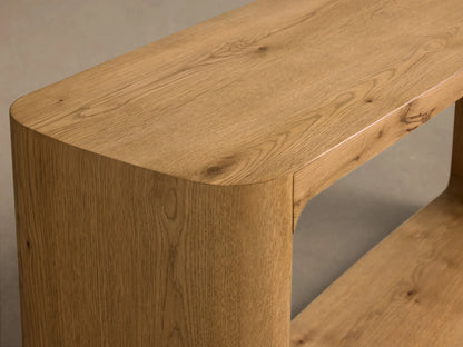 Front view of the Redding Console Table, made of light natural oak wood, with rounded corners and a lower shelf.