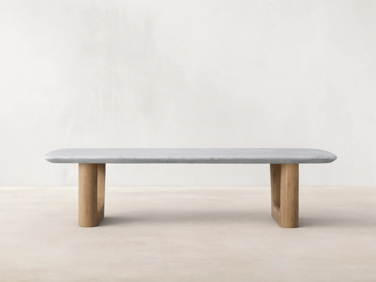 Front view of the Saint Germain Stone Coffee Table with Rennes Base, a light gray marble top with rounded edges and light brown oak legs.