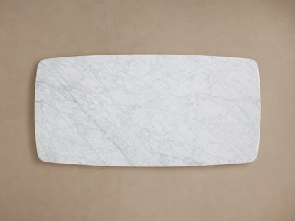 Rectangular coffee table with a Carrara marble top, showcasing light gray veining on a white surface. Rounded edges with a smooth finish.