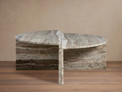 Riggs Coffee Table with semi-circular marble top, visible natural veins, and matching base on wooden floor, beige background.