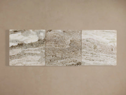 Three rectangular stone slabs with a marbled pattern in shades of cream and gray, aligned horizontally against a beige background.