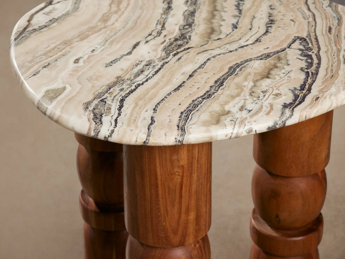 Rune End Table with a round, marbled white and gray stone top, supported by three carved, cylindrical wooden legs.