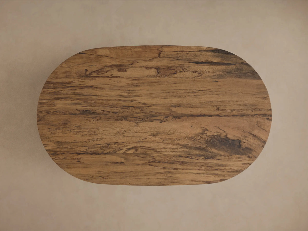 Front view of the oval San Rafael Coffee Table, featuring an aged brown wood finish and a distinctive arched base.