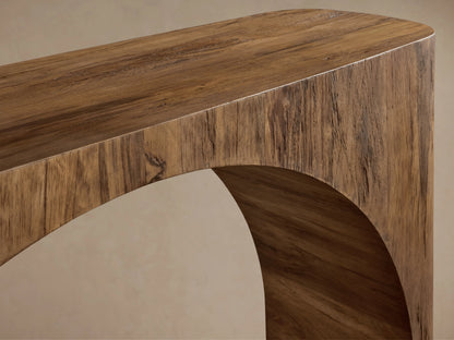 San Rafael Console Table close-up: aged, textured brown primavera wood with distinct grain and a graceful curved support.