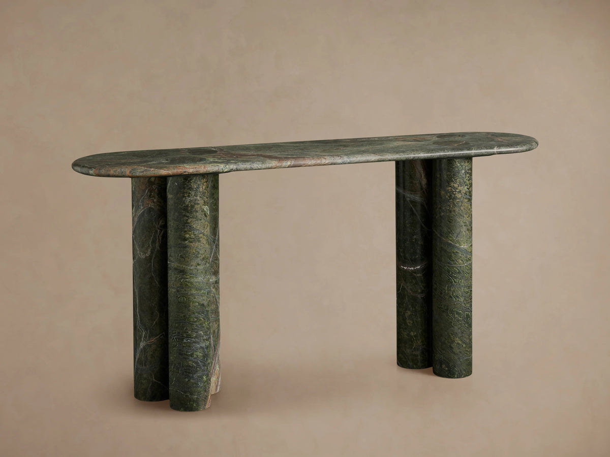 Serafin Console Table, oval green marble top, three rounded column legs on each side, against a neutral wall & wood floor.