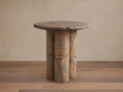Serafin End Table with a round stone top and three cylindrical legs. Natural veining in shades of brown, highlighting a modern design.
