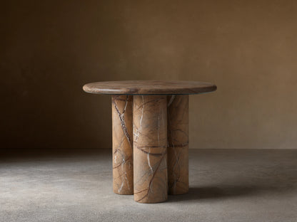 Serafin End Table with a round stone top and three cylindrical legs. Natural veining in shades of brown, highlighting a modern design.