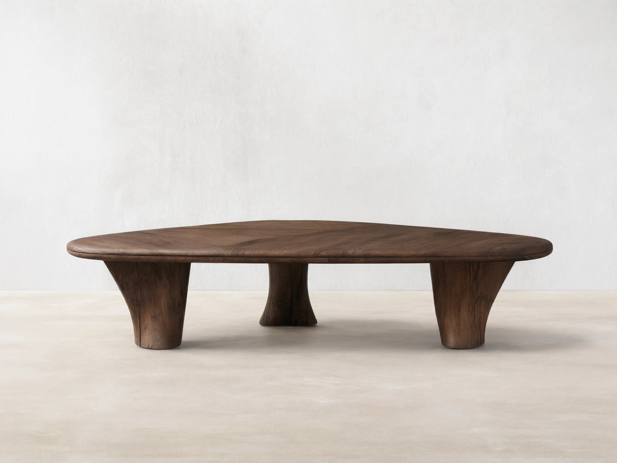 Soumaya Coffee Table: Organic, triangular spalted primavera wood coffee table with radial grain top, thick mahogany legs on wood floor.
