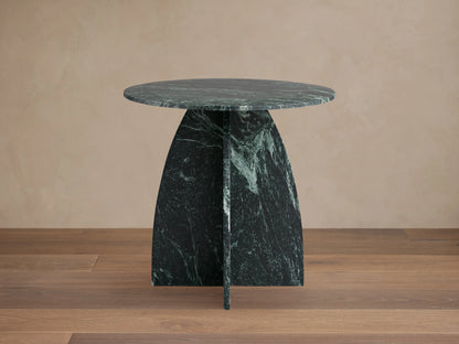 Solstice End Table with round green marble top and matching curved table legs, showcasing unique veining patterns.