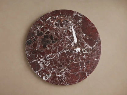Round Solstice End Table top made of rich red marble with white veining, showcasing a polished, natural stone texture.