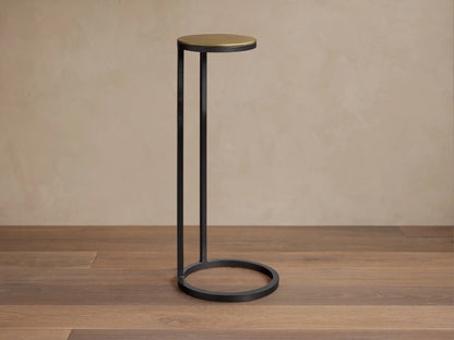 Front view of the Soma Martini Table, featuring a round gold top and a black metal frame with a circular base.