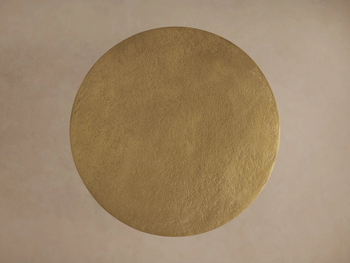 Top-down view of the circular gold aluminum tabletop of the Soma Martini Table with a textured, hand-applied patina finish.