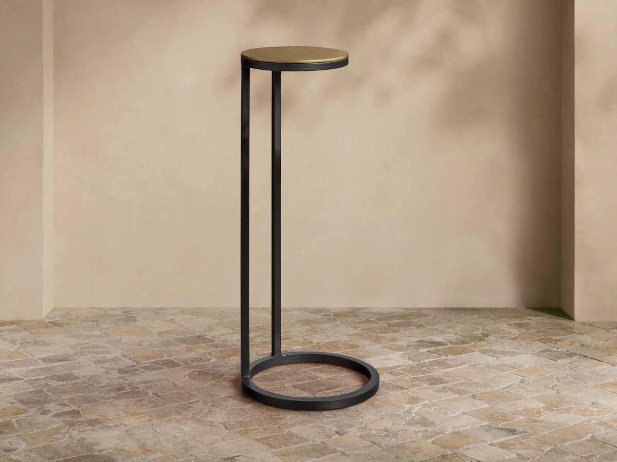 Close-up of the Soma Martini Table, featuring a round, textured, patinaed gold aluminum tabletop and a black powder-coated base.