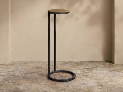 Close-up of the Soma Martini Table, featuring a round, textured, patinaed gold aluminum tabletop and a black powder-coated base.
