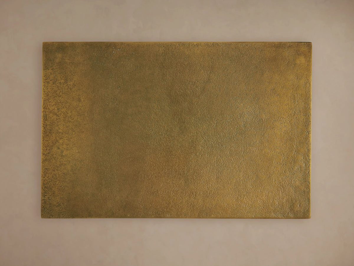 Front view of the Soma C Table, featuring a rectangular gold patinaed tabletop and a black C-shaped frame.