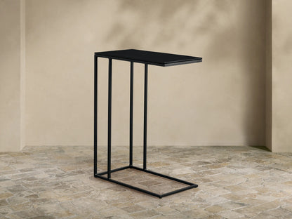 Black Soma C Table with a thin rectangular top and C-shaped base, featuring a minimalist design, against a neutral wall.