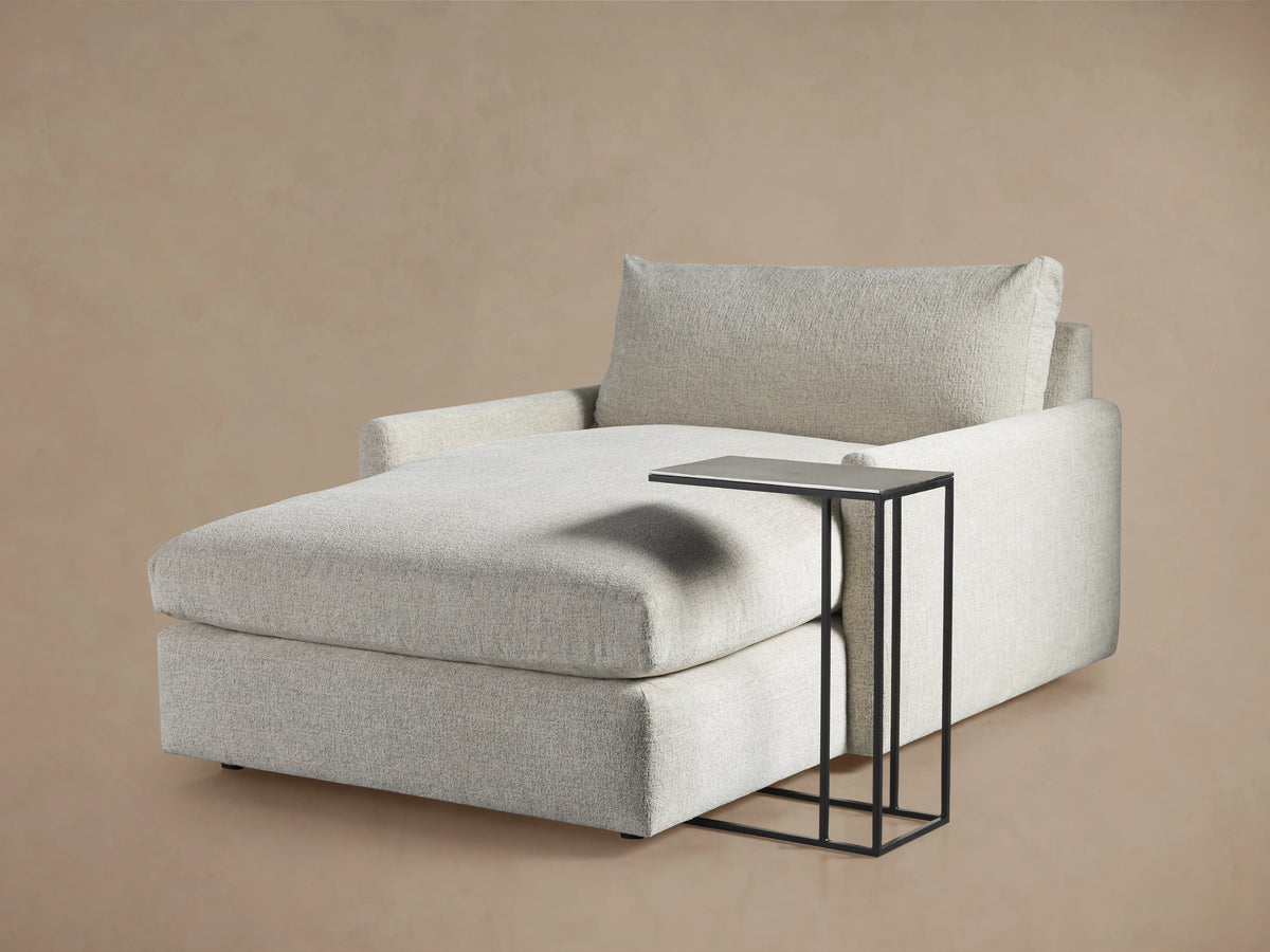 Soma C Table with a textured dark aluminum tabletop and sleek metal edges, supported by slim iron legs.