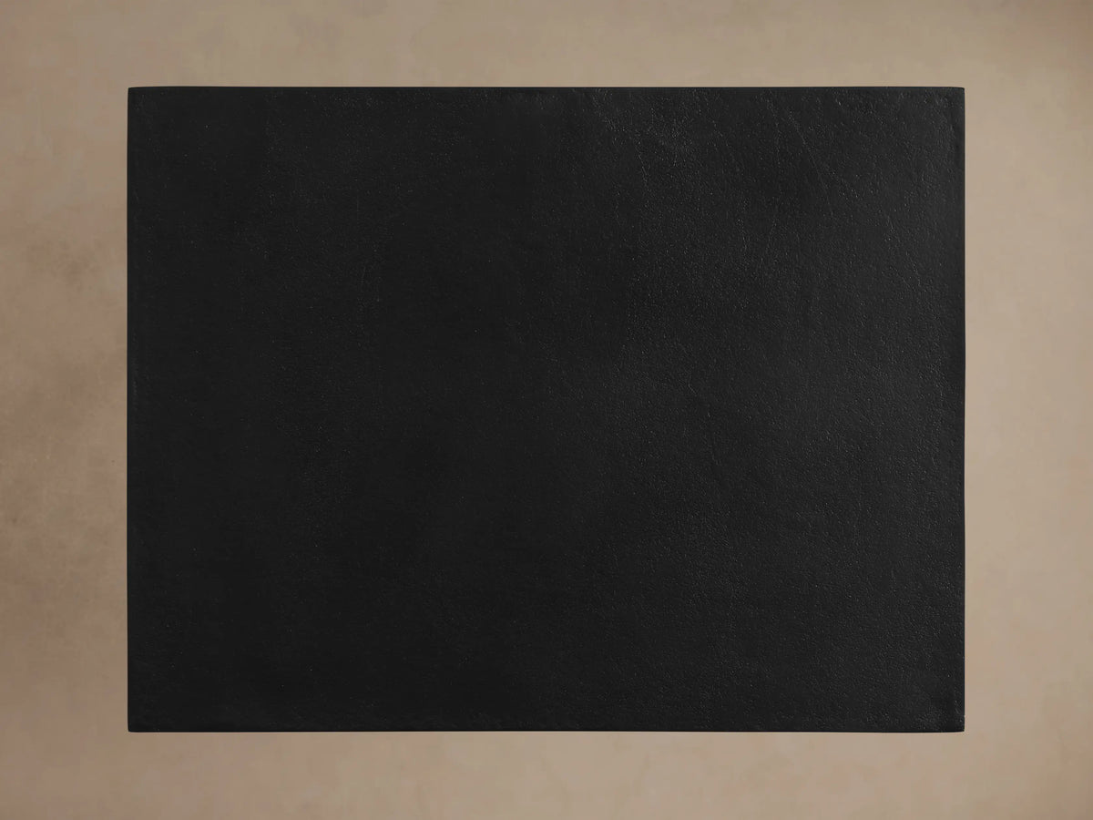 Soma C Table, top-down view of its rectangular black, textured tabletop against a light beige background.
